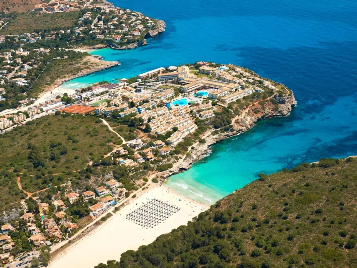 Una veduta aerea del Blau Punta Reina Resort, un rifugio sulla spiaggia che incarna la perfetta combinazione di bellezza naturale e comfort moderni.