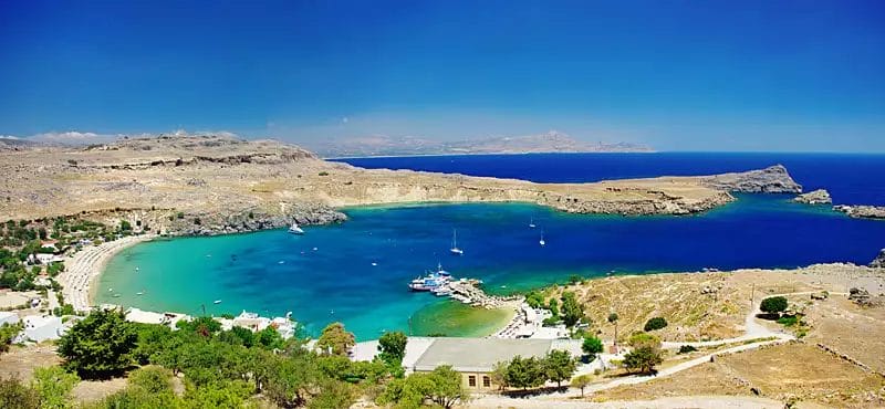 Una veduta aerea della spiaggia di Lardos Bay con barche e acqua blu.