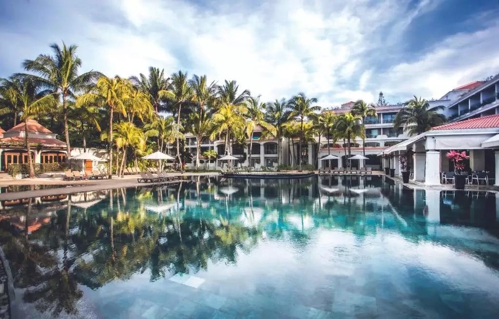 La piscina del resort MAURICIA BEACHCOMBER è circondata da palme.