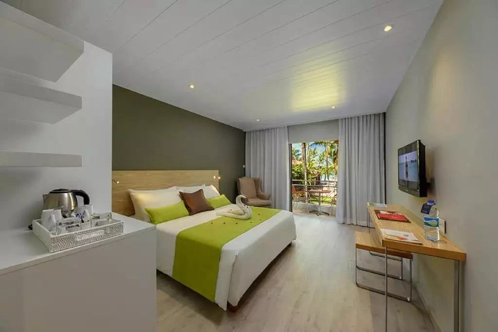 Una camera d'hotel premium al Mauricia Beachcomber con un letto e un televisore.