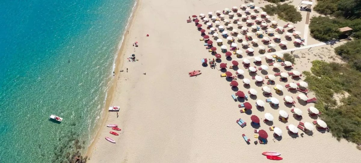 Una veduta aerea della spiaggia dell'ALPICLUB ALMA RESORT con ombrelloni e sdraio.