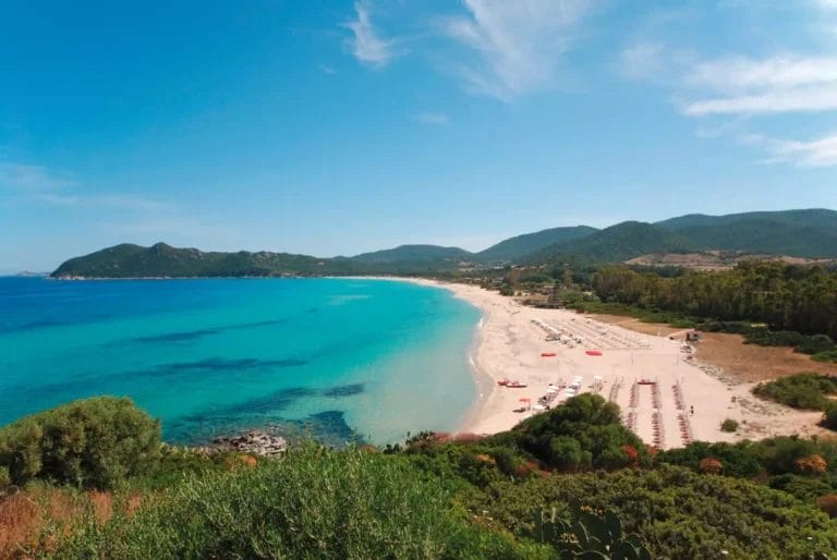 Una spiaggia con acqua azzurra e sabbia bianca, perfetta per una rilassante vacanza ALMA RESORT.