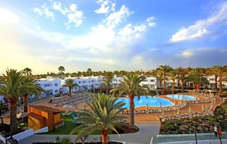 Veduta aerea di un resort nel villaggio di Corralejo con piscina e palme.