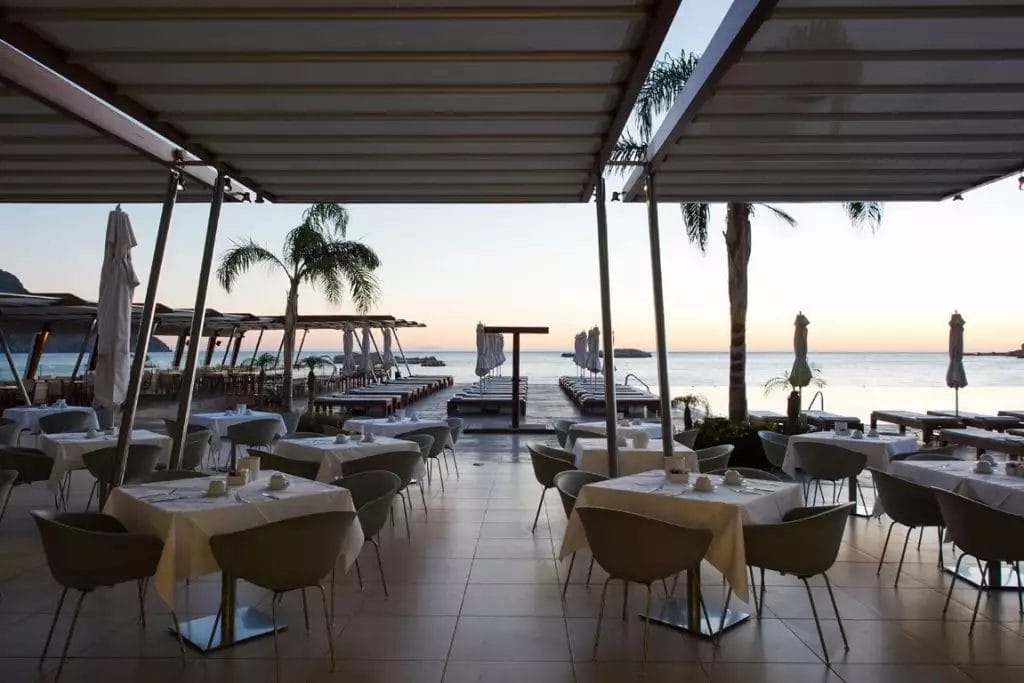 Un ristorante con tavoli e sedie con vista sull'oceano.