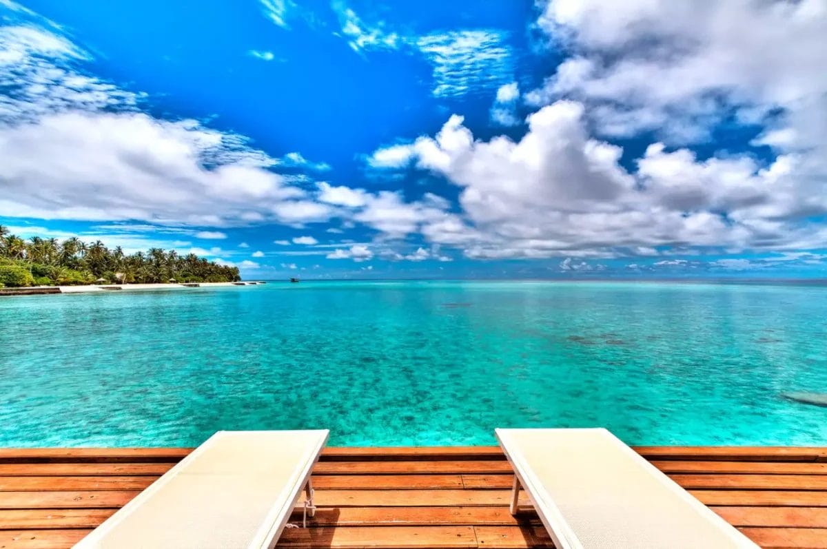 Due sedie a sdraio BRAVO su una terrazza in legno con vista sull'oceano.