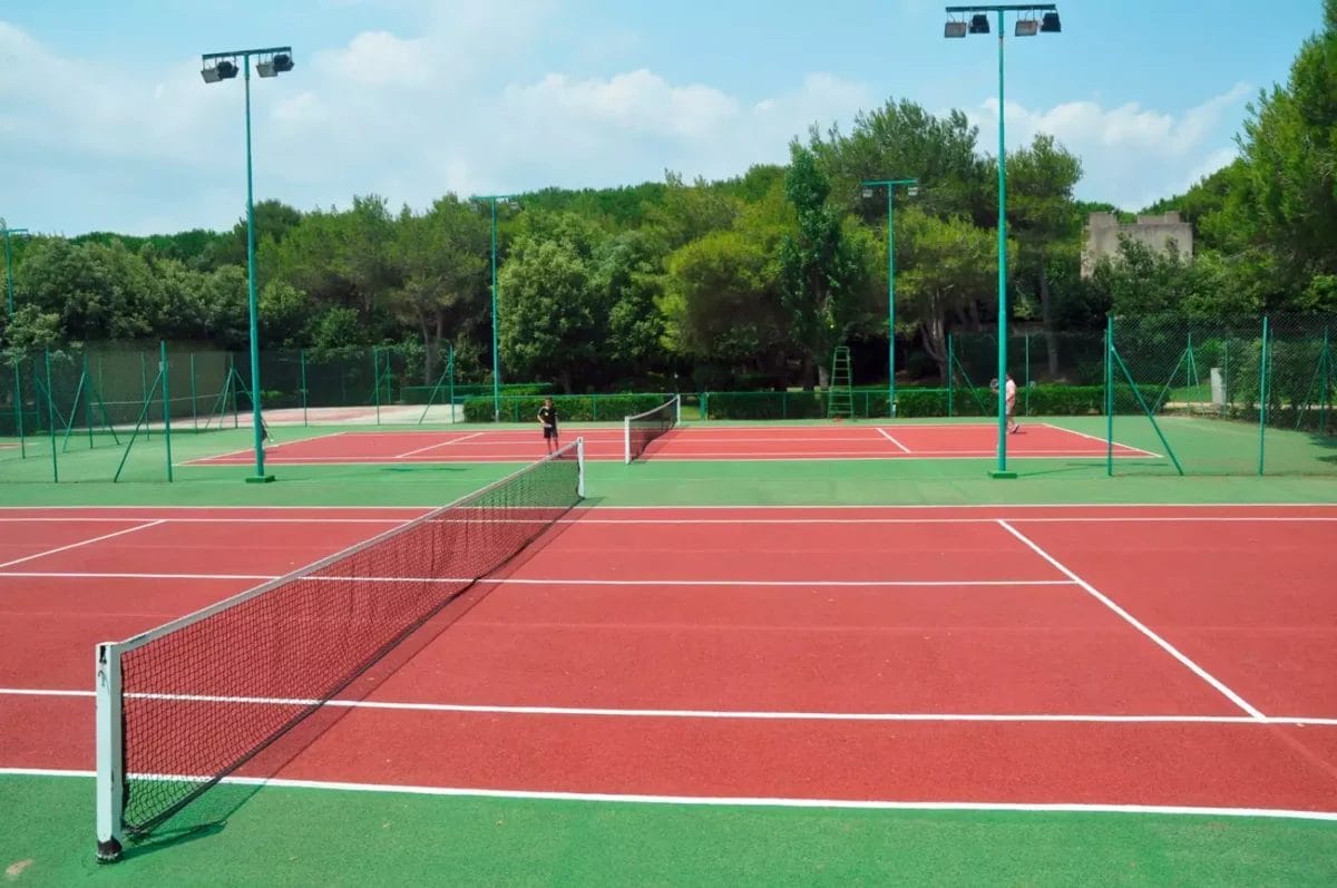 Un campo da tennis Bravo Alimini con linee bianche e rosse.