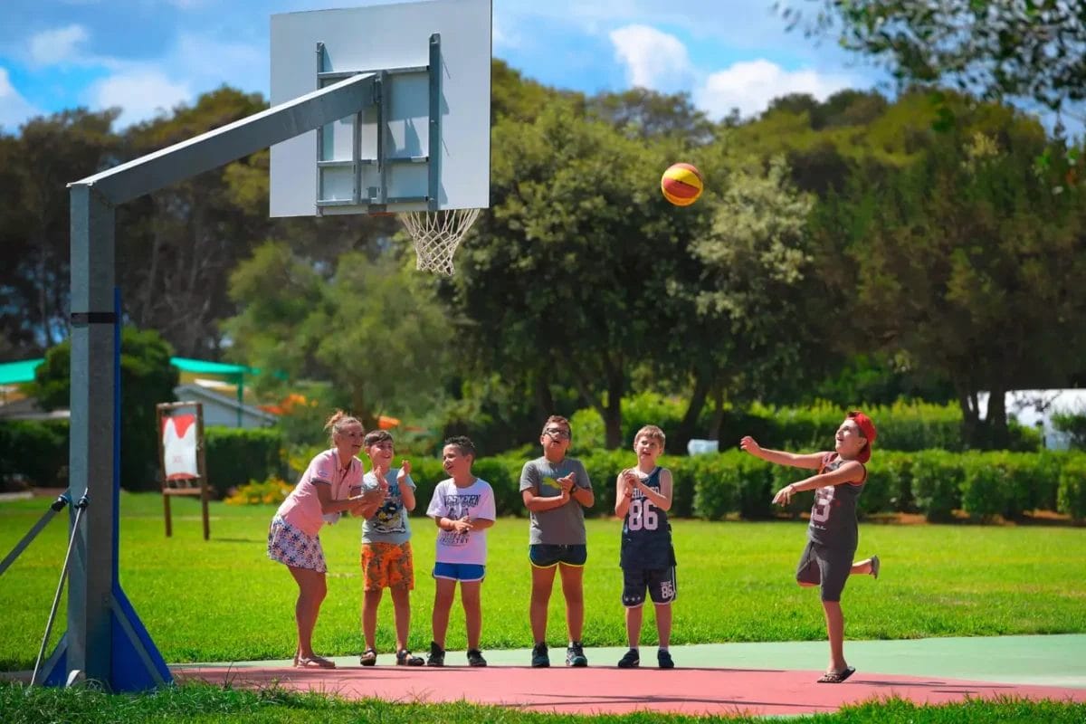 BRAVO Un gruppo di bambini ALIMINI giocano a basket in un parco.