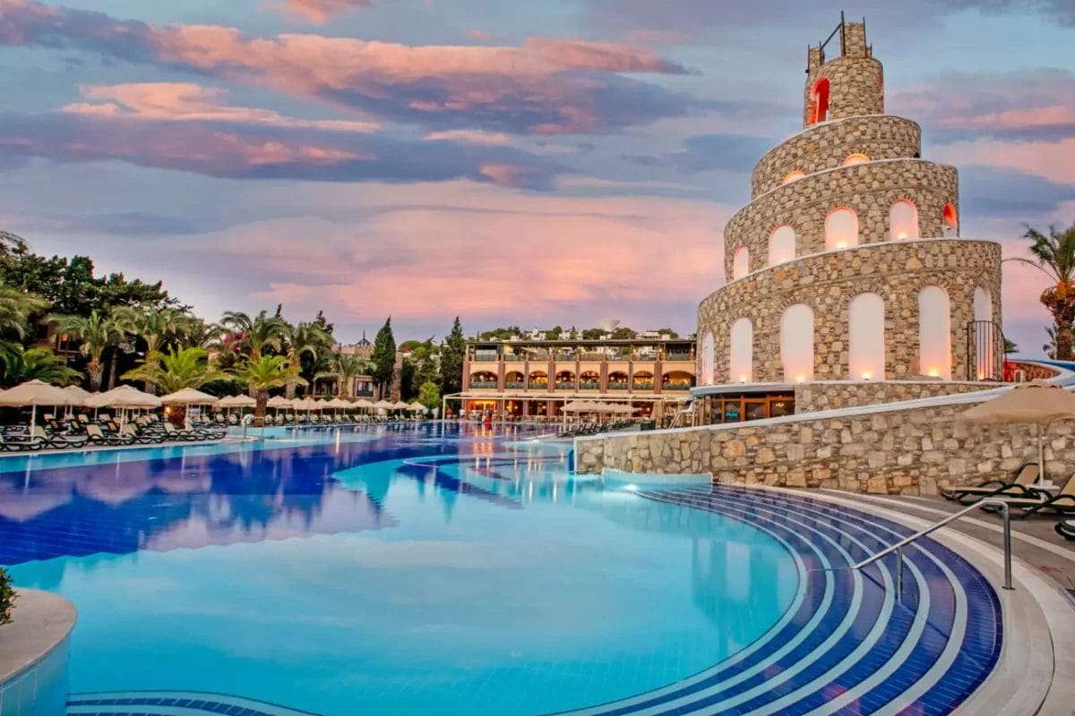 Una piscina imperiale al tramonto con un castello sullo sfondo.