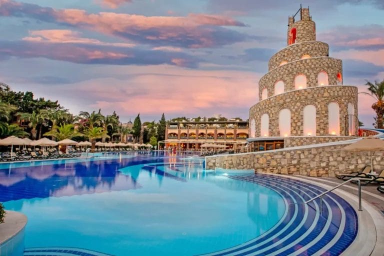 Una piscina imperiale al tramonto con il castello Bravo Bodrum sullo sfondo.