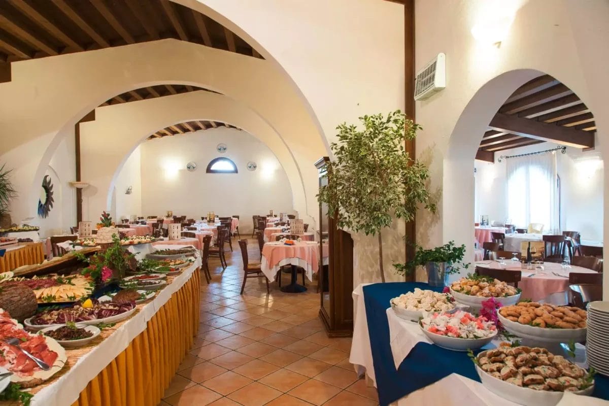 Una grande sala da pranzo con tanto cibo in tavola al Bravo.