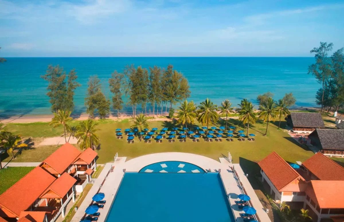 Un resort PREMIUM con una vista aerea degna di Bravo che mostra una splendida piscina e una spiaggia incontaminata a Khao Lak.