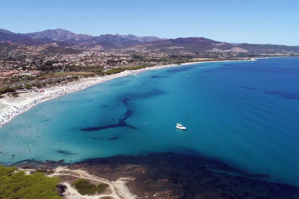 Una veduta aerea della splendida spiaggia BRAVO incastonata tra le maestose montagne di BUDONI.