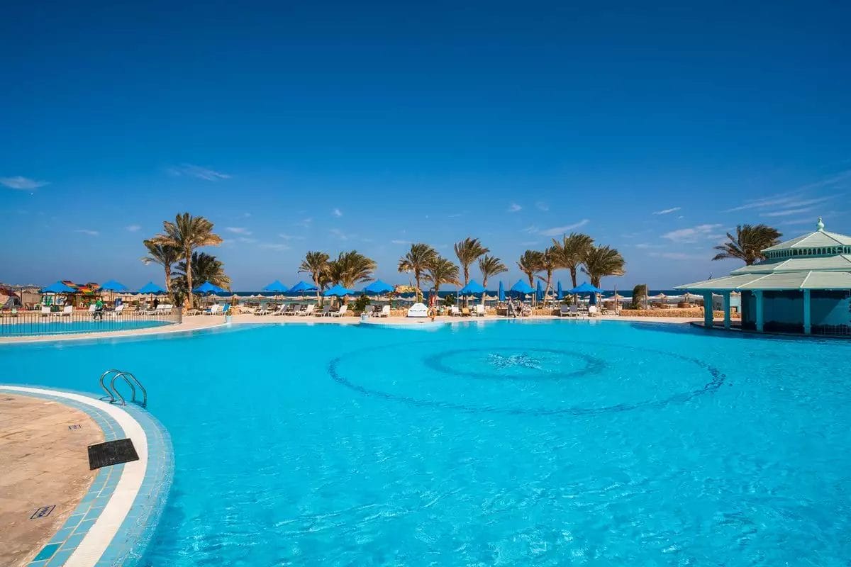 Moreen Beach, un resort con un'ampia piscina circondata da lettini e palme.