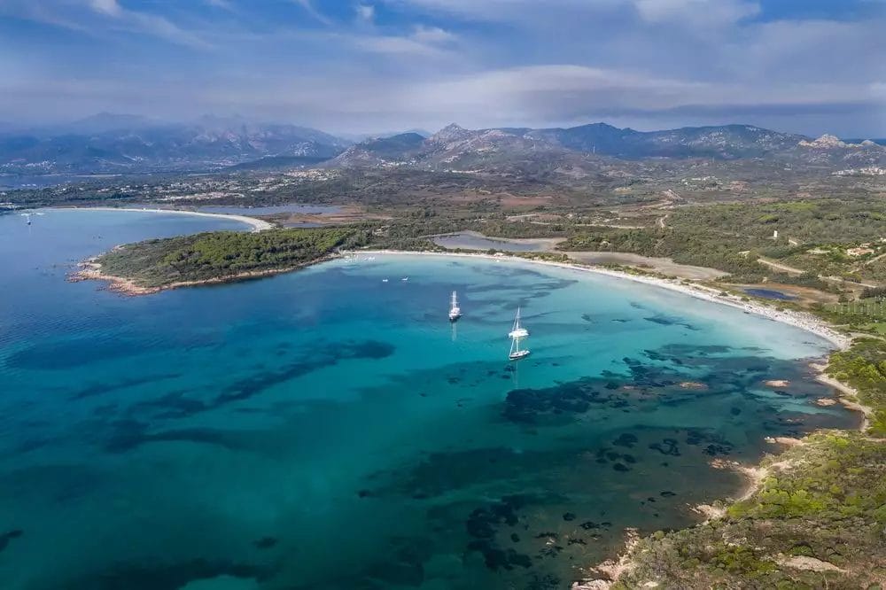 Veduta aerea di una spiaggia con barche a vela in acqua al FUTURA CLUB.