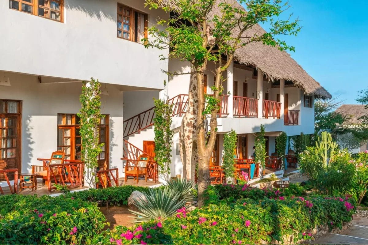 UN JACARANDA BEACH RESORT in Kenya con tetti di paglia e alberi.