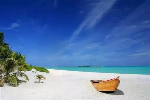 Una barca di legno si trova su una spiaggia PREMIUM KHAO LAK.