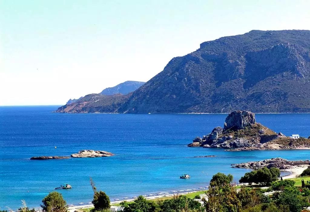 Una vista di una spiaggia con una montagna sullo sfondo al VERACLUB KOS.