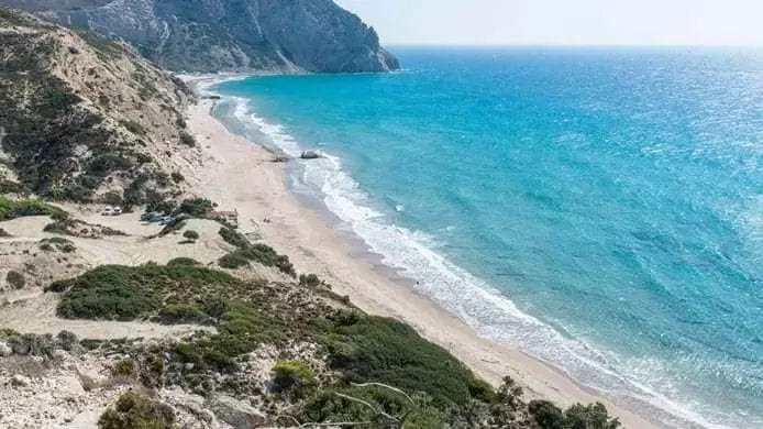 Una veduta aerea di una spiaggia vicino a una scogliera che si affaccia sulla costa mozzafiato di KOS.