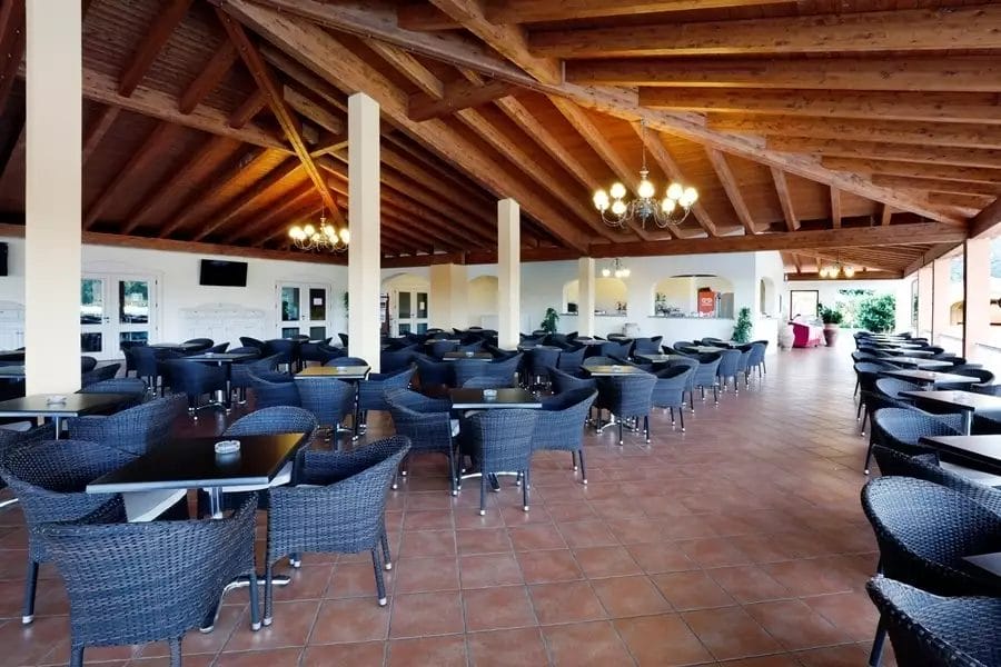 Marina Rey Beach Resort, un ristorante con soffitto in legno e tavoli e sedie.