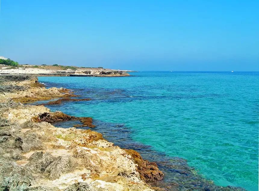 Una costa rocciosa con acqua cristallina e un litorale roccioso.