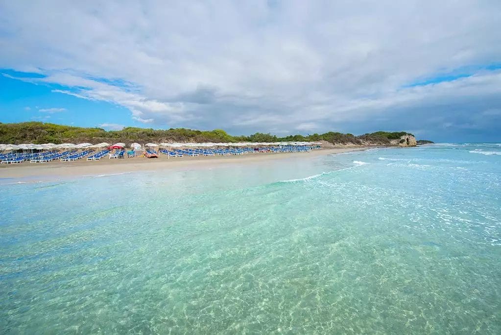 Una spiaggia dall'acqua limpida e ombrelloni azzurri, trasformata nel paradiso ALPISELECT.