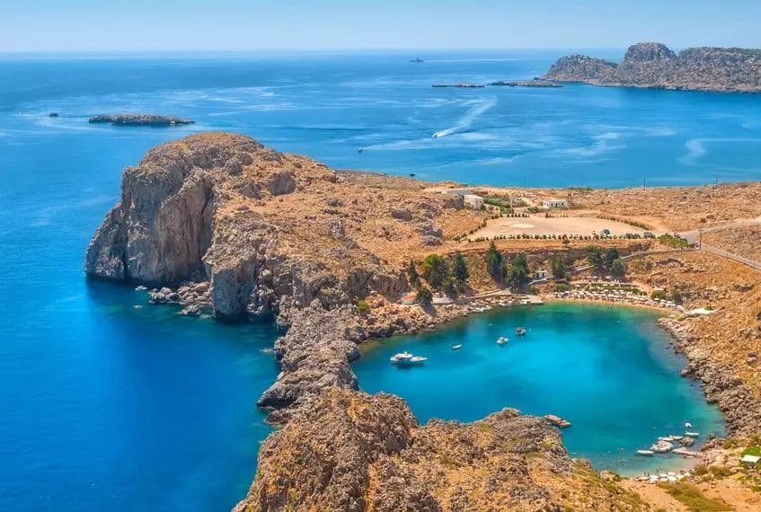 Una veduta aerea dell'ALPICLUB Lindos Princess, circondato da un mare blu mozzafiato e spettacolari scogliere rocciose.