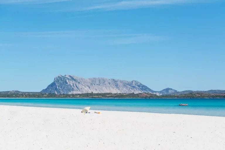 Una spiaggia di sabbia bianca con una montagna sullo sfondo è la suggestiva cornice di Baja Bianca, un rifugio esclusivo situato al Futura Club.