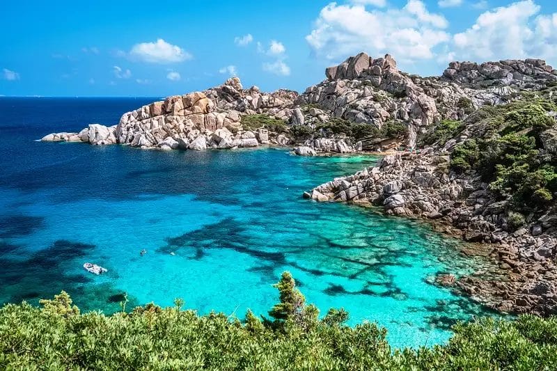 Una splendida spiaggia con acqua cristallina e scogliere rocciose, situata presso il Club Esse Gallura.