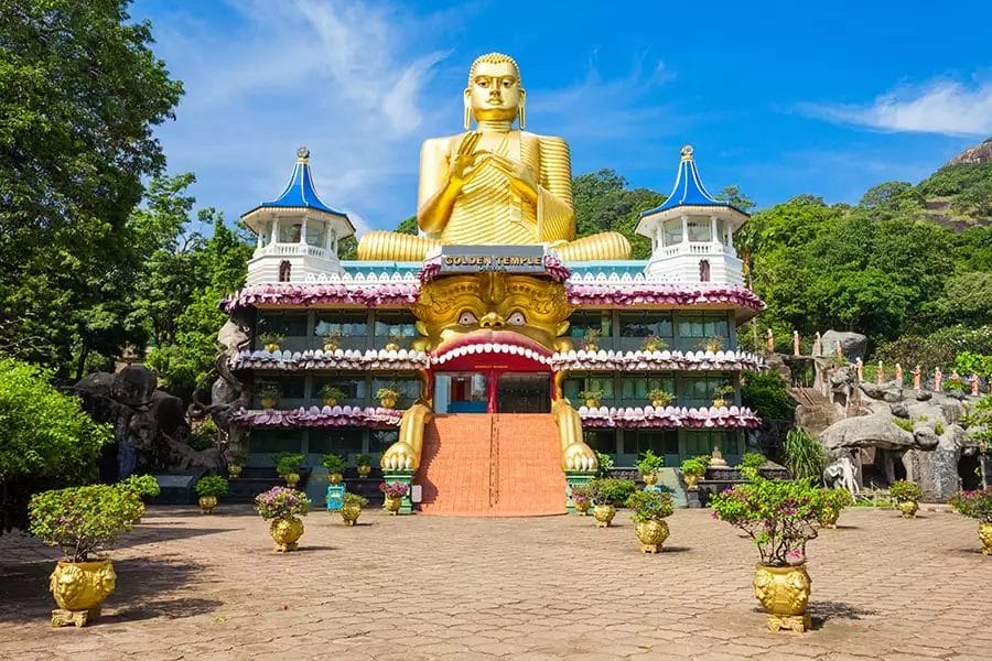 Statua dorata del Buddha davanti a un tempio nello Sri Lanka.