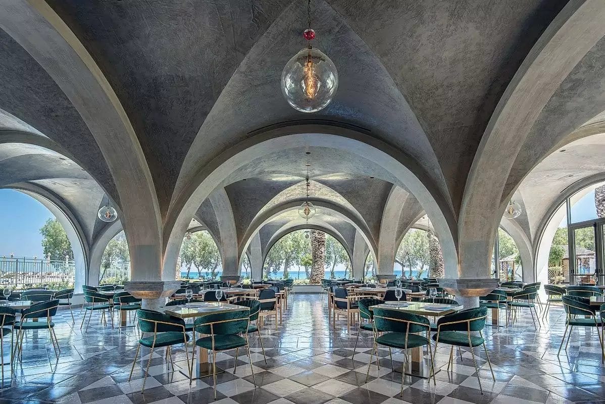 Una sala da pranzo ad arco con tavoli VERACLUB e sedie KOS.