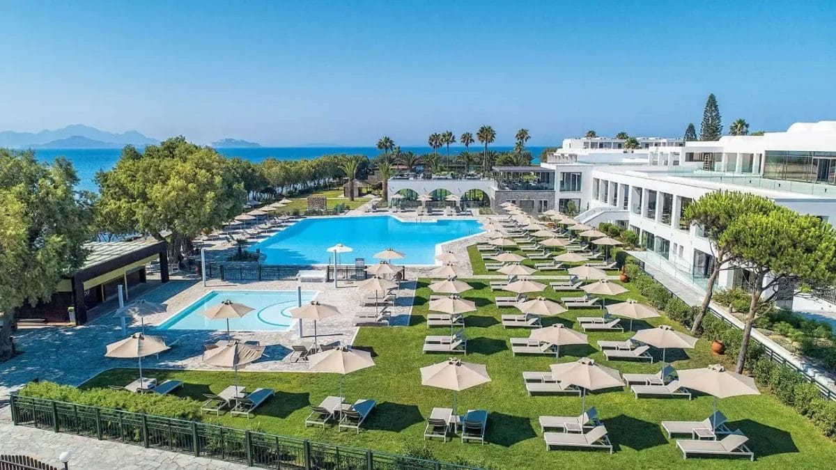 Una veduta aerea di un KOS. hotel con piscina e sedie a sdraio.