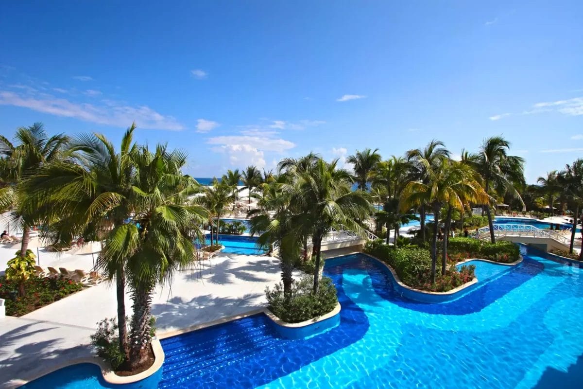 Una lussuosa piscina a Bahia Principe con palme.