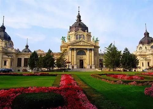 Un edificio dall'architettura barocca con giardini ben curati in primo piano, situato a Vienna.