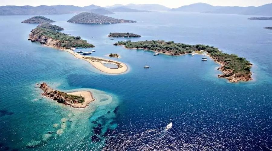 Veduta aerea di un arcipelago sereno con isole verdi e lussureggianti circondate dalle acque cristalline di un mare tranquillo in Turchia.