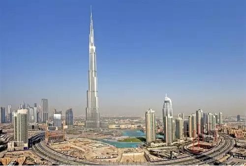 Una grande città con un'alta torre con il Grand Hyatt sullo sfondo, che domina il Burj Khalifa.