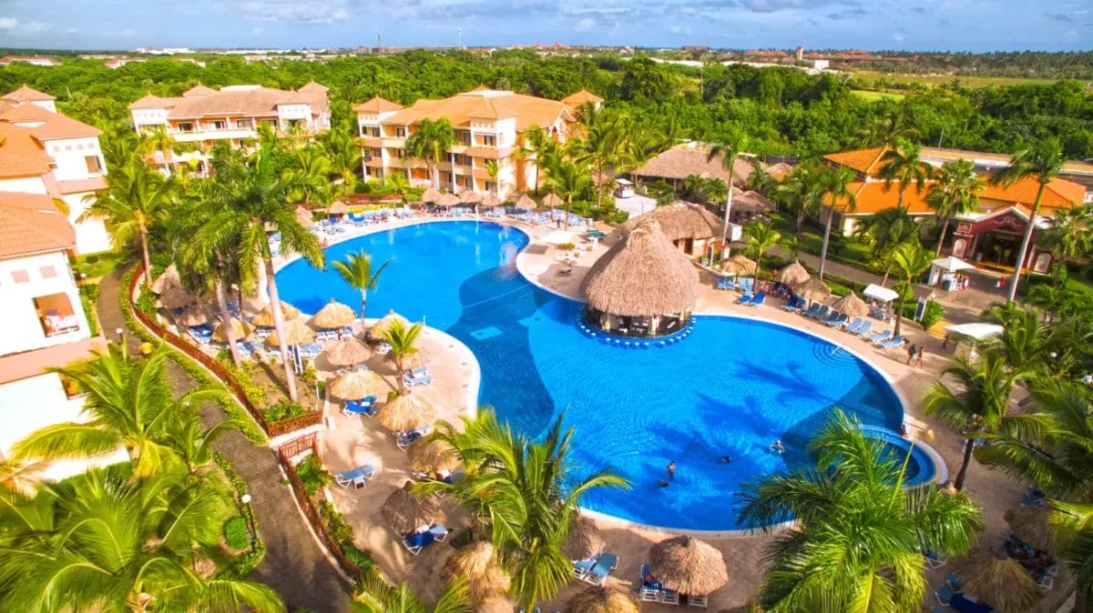 Veduta aerea del resort Grand Bahia Principe Turquesa con una grande piscina e palme.