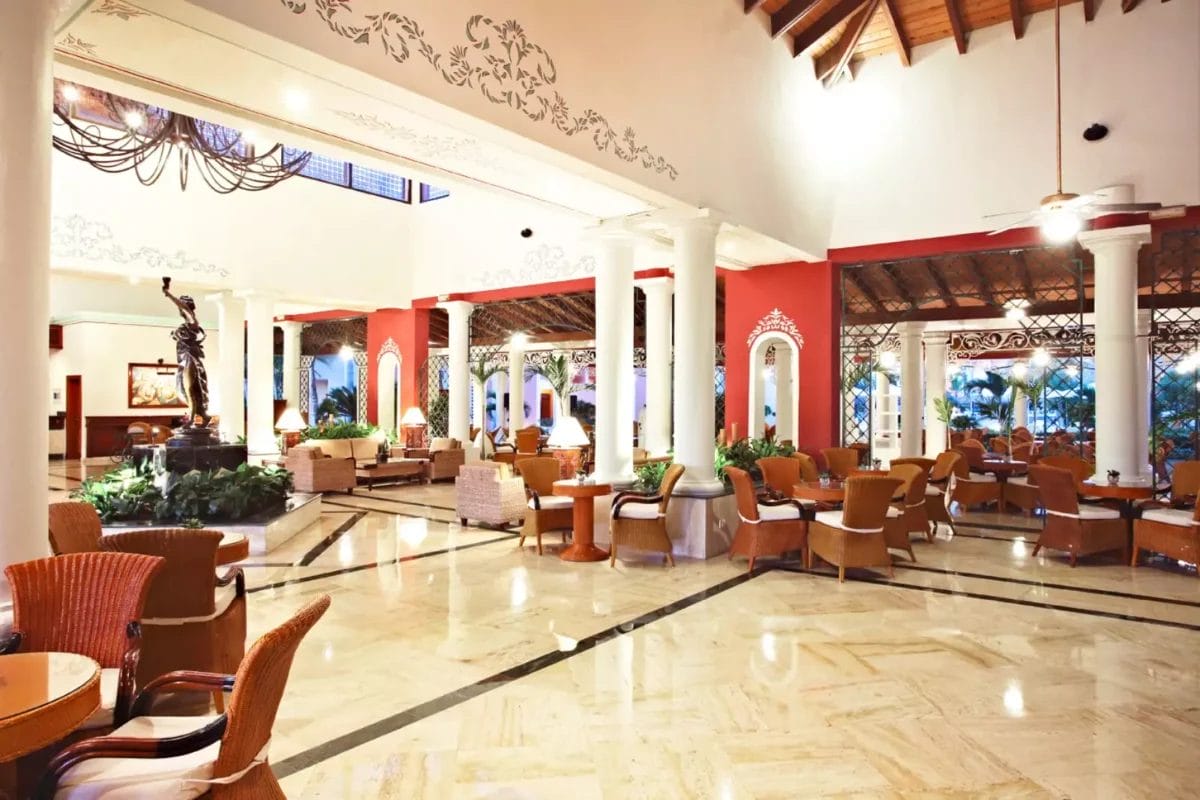 Spaziosa hall dell'hotel con arredi eleganti e aree salotto al Grand Bahia Principe Turquesa.