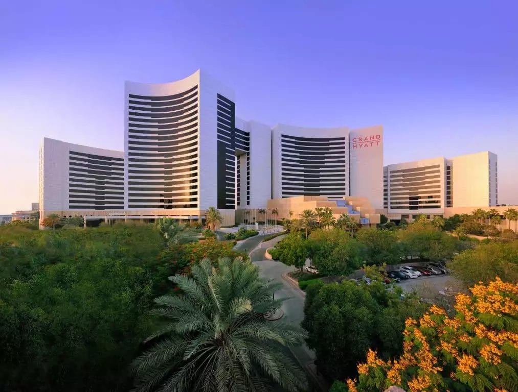 Un grande hotel di lusso con alberi e parcheggio.