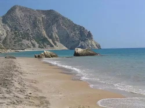 Spiaggia sabbiosa con acque calme e Kipriotis Hippocrates sullo sfondo.