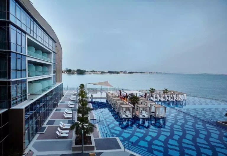 Lussuosa terrazza sul mare del Royal M Hotel Abu Dhabi con eleganti mobili da esterno e splendide viste sull'oceano, che mostrano eleganza rilassata e design moderno.