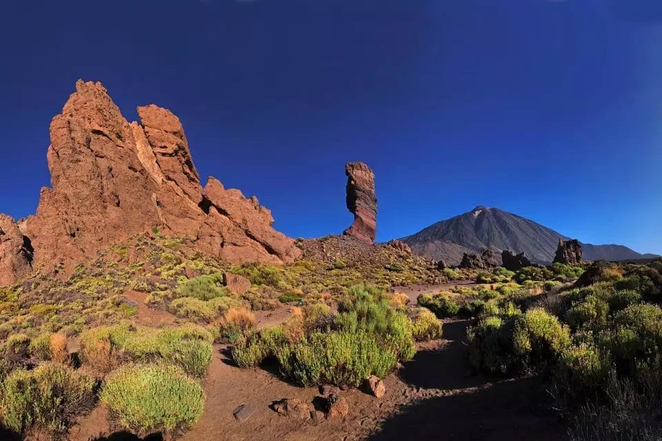 Scopri la maestosità vulcanica: imponenti formazioni rocciose e il Monte Teide sotto un cielo azzurro e limpido nel Parco Nazionale del Teide, a Tenerife, con il viaggio Veraclub Gala.