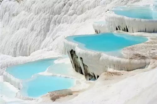 Piscine minerali terrazzate di Pamukkale, una meraviglia naturale in Turchia, che offre un paesaggio surreale di formazioni di travertino bianco e acque turchesi, perfetto per un tour.