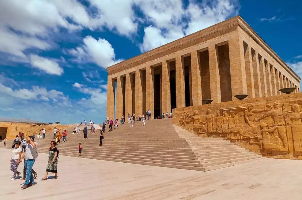 Un gruppo di persone sta facendo un tour esclusivo, passeggiando intorno a un grande edificio in Turchia.