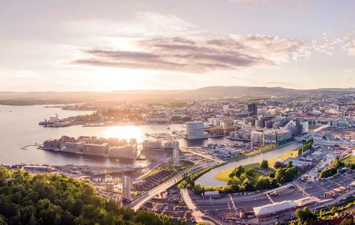 Veduta aerea di una città al tramonto con i corsi d'acqua e gli edifici moderni dei Fiordi Norvegesi.