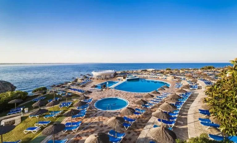 Il resort fronte oceano, FARRAGUT GLOBALES ALMIRANTE, dispone di una grande piscina circolare circondata da sedie a sdraio e ombrelloni, con vista sull'oceano. I sentieri piastrellati e il bar a bordo piscina aggiungono fascino mentre il sole tramonta all'orizzonte.