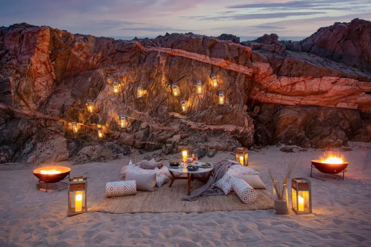 Al tramonto, la spiaggia si trasforma in un'oasi esclusiva, che ricorda un campo magico dove accoglienti posti a sedere adornano la sabbia. Cuscini, lanterne e un tavolo basso circondano i bracieri sotto scogliere rocciose illuminate da lanterne, che ricordano la bellezza serena di Alila Hinu Bay.