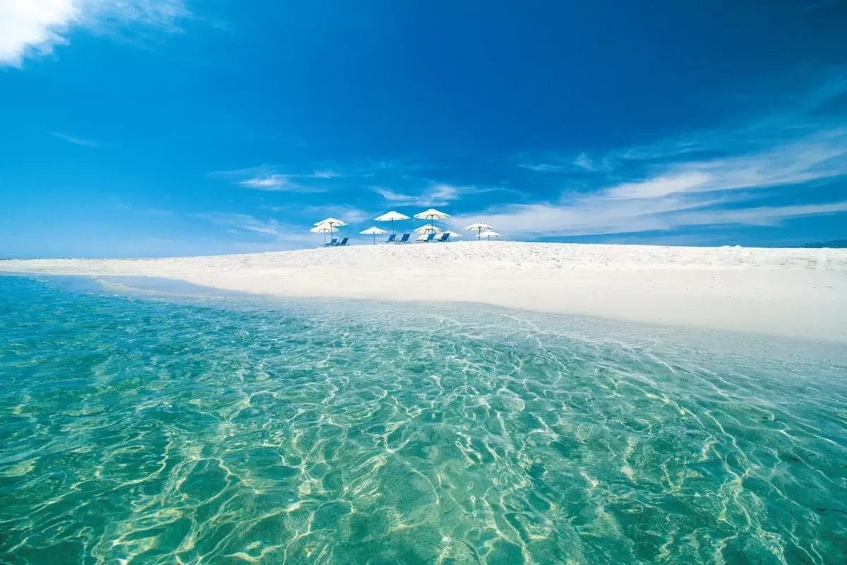 Vivi la magia della baia di Alila Hinu, dove le limpide acque turchesi incontrano una spiaggia di sabbia bianca adornata da ombrelloni sotto un perfetto cielo azzurro, offrendoti un rifugio esclusivo in Oman.