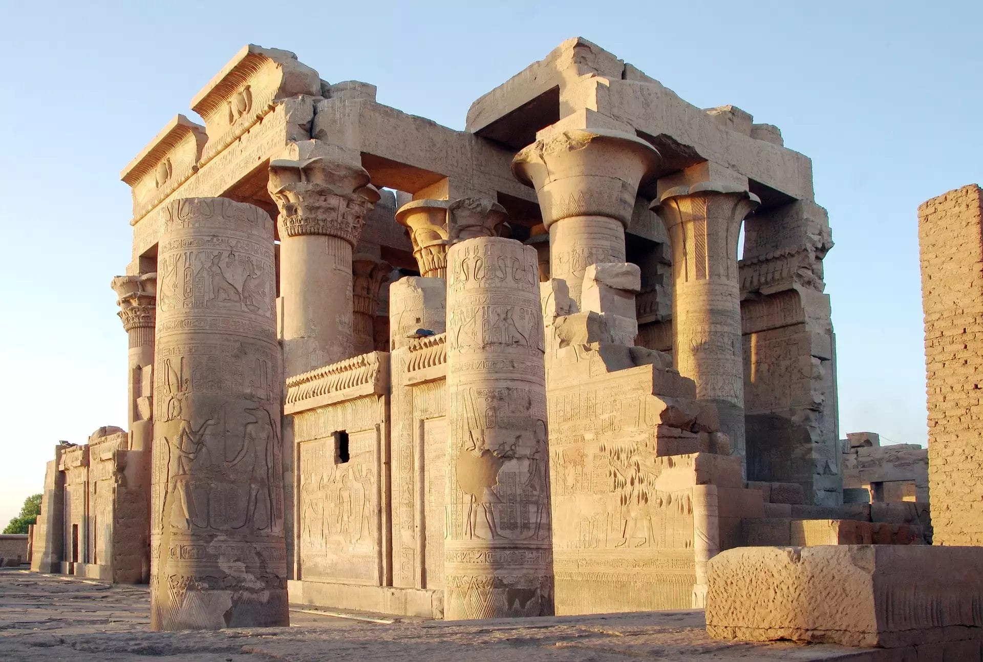 Sotto il cielo terso e azzurro, l'antico tempio egizio di Kom Ombo si erge maestoso, con le sue intricate incisioni su colonne e pareti che riecheggiano i racconti di *Le Rive degli Dei*. Questo gioiello architettonico invita i visitatori a esplorare i sussurri della storia in un paradiso un tempo divino.