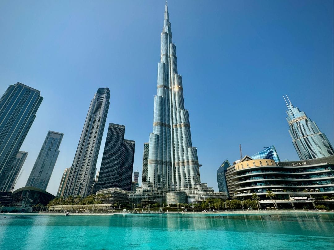 Ammirate il grattacielo Burj Khalifa a Dubai, con il cielo blu sopra e la piscina turchese in primo piano: una vista iconica in ogni avventura di TOUR DUBAI 2025.