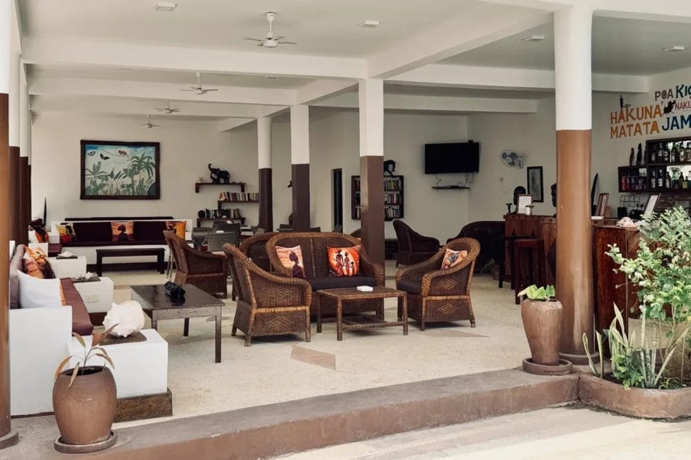 L'ampio salone interno del BLU MARLIN BEACH RESORT è caratterizzato da sedie e divani in vimini, cuscini a tema tropicale, piante in vaso, un bar sulla destra e una grande palma a muro sulla sinistra. L'arredamento del resort sulla spiaggia è rilassato e invitante.